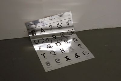 Poster auf Spiegelpapier. Überschrift 'Tpe & Chairs', darunter viele Buchstaben in verschiedenen Schriften in einem gleichmäßigen Raster.