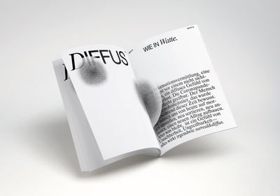 Aufgeschlagenes Magazin. Links Titel in Großbuchstaben: Diffus, Rechts Fließtext. Unscharfe, runde Strukturen sind überlagert