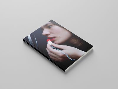 Geschlossenes Buch auf hellgrauem Grund. Das Cover ist ein Foto einer jungen Frau, die mit einem Tampon Lippenstift aufträgt.